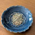 Blue ceramic bowl with herbal tea on a wooden surface